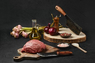 Raw beef petite sirloin with ingredients on black background