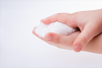 Hand holding some cotton in hand on a white background