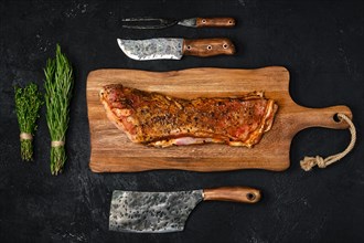 Top view of grilled lamb breast and flap on wooden cutting board