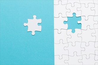Single white jigsaw puzzle piece blue background