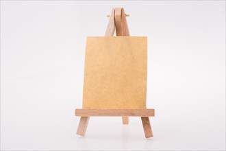 Brown color notepaper on a painting tripod on white background