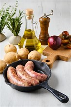Homemade sausage stuffed with beef and turkey meat in frying pan