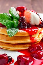 Macro photo of pancakes with strawberry and black currant jam