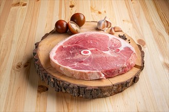 Piece of fresh pork shoulder on wooden cutting board