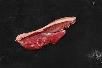 Overhead view of raw beef ribeye lip on with skin on black background