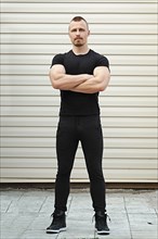 Full length portrait of Fitness instructor with arms crossed