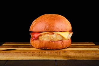 Simple burger with fish patty on wooden board