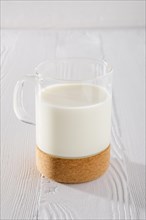 Glass of milk on white wooden kitchen table