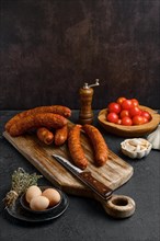 Homemade hot moked beef sausage in organic casing on wooden cutting board