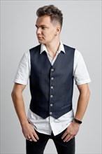 Portrait of trendy man in white shirt and vest looking to the right