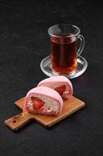 Sweet dessert mochi with strawberry cut on half with fruit tea