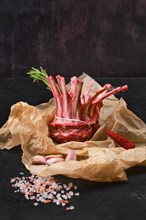 Rolled and tighted raw fresh rack of lamb on kitchen table