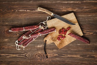 Overhead view of sun dried pork sausages on wooden background