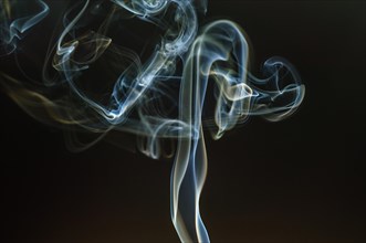 Trajectory of incense smoke in the air showing different shapes. France