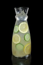 Decanter with lemon and cucumber lemonade isolated on black