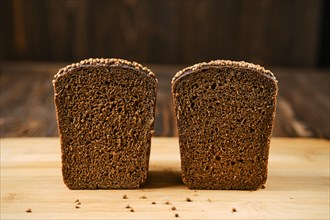Closeup view of fresh rye brown bread on wooden cutting board