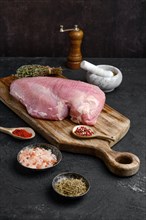 Raw fresh turkey boneless breast without skin on dark background