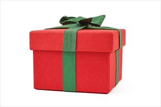 Side view of red Christmas gift box with green ribbon on white background