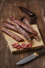 Air dried homemade beaver sausages on wooden background