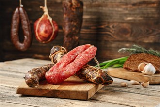 Air dried beef meat and pork and turkey sausage on wooden cutting board