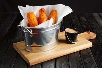 Snack for beer. Fried breaded cheese with sauce served in metal backet