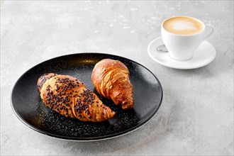 Cappuccino and two croissants on a table