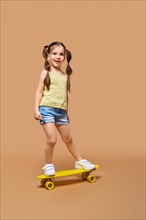 Young happy girl learning to ride on skateboard