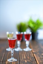 Vodka infused with berries on wooden background