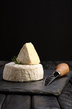 Brie cheese or camembert on stone board with knife for soft cheese