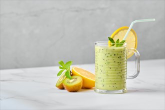 Kiwi and lemon smoothie with mint on marble table