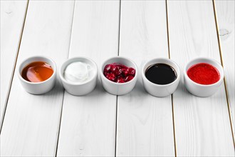 Assortment of different sauce on white wooden table