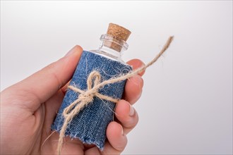 Little empty bottle covered with denim canvas in hand