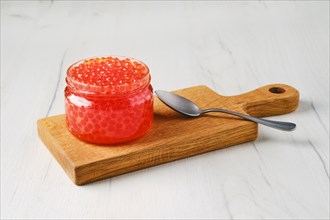 Open pot with pink salmon red caviar