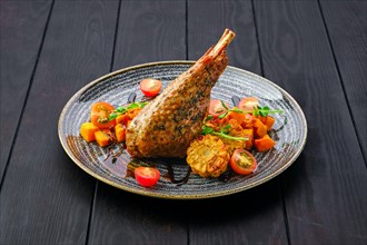 Roaster turkey leg with fried pumpkin and grilled corn decorated with tomato