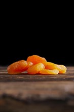 Small heap of dried apricots on wooden table
