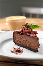 Close up view of piece of chocolate cake with cappuccino