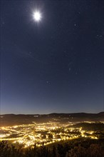 City lights with starry sky and moon