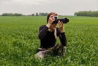 Wildlife photographer makes pictures with telephoto lens at the field