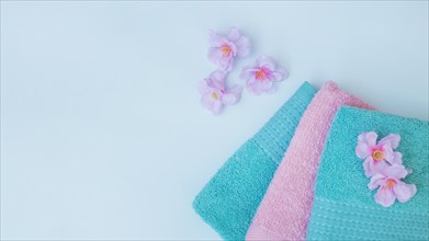 Elevated view towels with purple flowers blue background