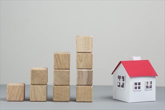 Small house model stack increasing wooden block grey backdrop. Resolution and high quality beautiful photo