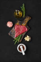 Overhead view of raw chuck eye steak with ingredients for cooking