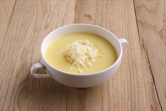Soup puree with cheese and mushrooms on wooden table