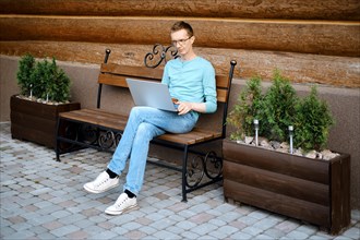 Middle aged man makes online order using laptop outdoors