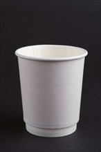 Cardboard cup without lid on dark background