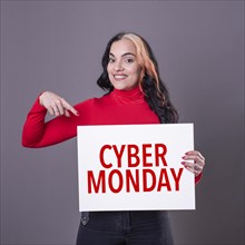 Beautiful woman pointing at a Cyber Monday sign. Commercial concept. Commerce