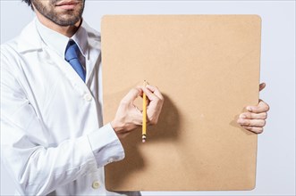 Doctor hands with pencil showing note chart with copy space. Doctor writing and showing a note board with space for text. Doctor concept writing on clipboard