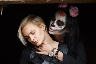 Female daemon with victim in hands. Face painting art