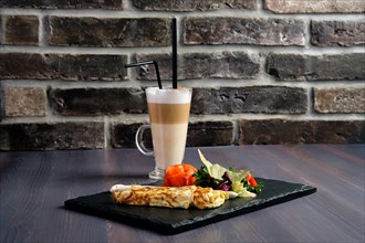 Omelette with salmon on slate plate and cup of latte