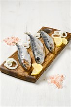 Salted iwashi herring fish marinated in spice on wooden cutting board
