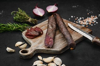 Beef dry aged sausage on wooden cutting board